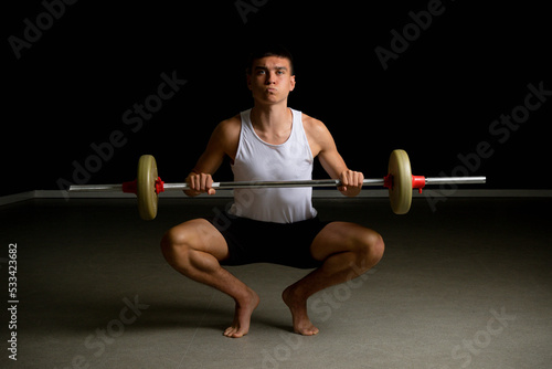 Nineteen year old teen boy exercising with a barbell