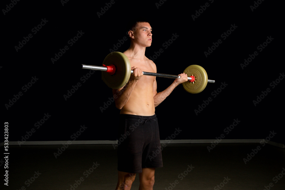 Obraz premium Nineteen year old teen boy exercising his biceps shirtless