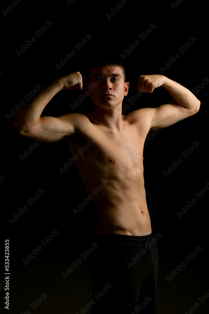 Nineteen year old teen boy flexing his arms