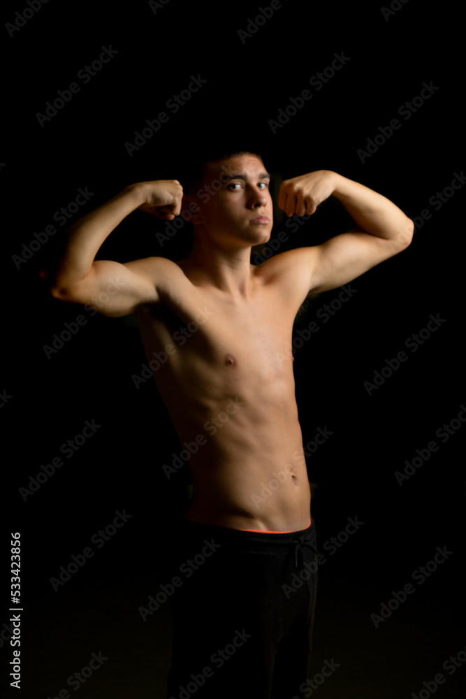 Nineteen year old teen boy flexing his arms Nineteen year old teen boy flexing his arms