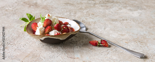 bowl with dessert with mascarpone and strawberries on a light table