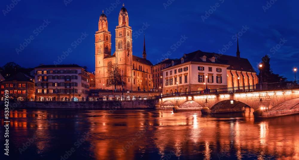 Panorama  image of evening Zurich. Amazing View on Grossmunster the protestent church with colorful sky during sunset. Zurich, Switzerland. Popular travel dectination.