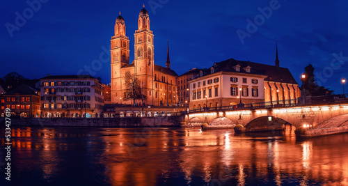 Panorama image of evening Zurich. Amazing View on Grossmunster the protestent church with colorful sky during sunset. Zurich, Switzerland. Popular travel dectination.