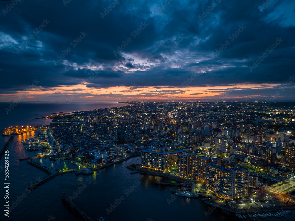 Fototapeta premium Dramatic sky over waterfront apartments in coastal city in early evening