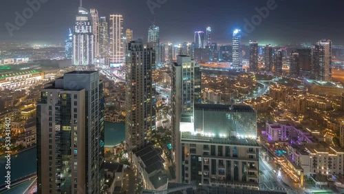 Aerial tiew of a big futuristic city day to night transition timelapse. Business bay and Downtown district with many skyscrapers and traditional houses, Dubai, United Arab Emirates skyline. photo