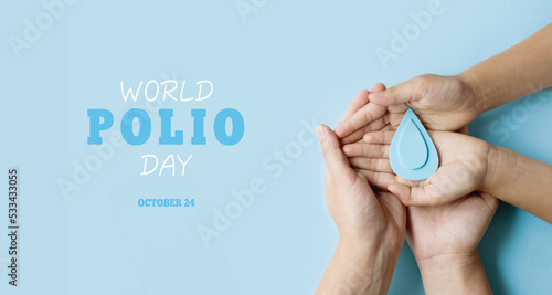 World Polio day. October 24. Blue drop in hands of an adult and child is symbol of polio vaccine. Poliomyelitis is disabling and life-threatening disease caused by poliovirus
