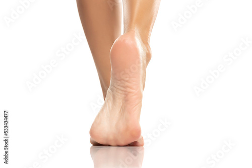 Pretty woman legs and sole feet on white background photo