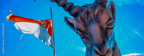 Horned animal shape with Austrian flag and blue sky in the background.