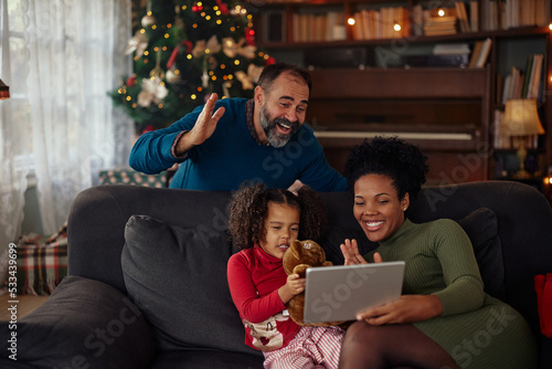 Cute little family using technology and having video call during Christmastime