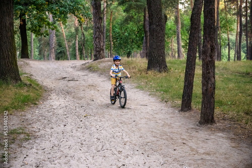 Cyclist Riding down the sandy Hill on the Offroad Trail