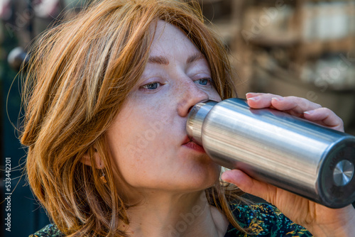 Tela Portrait of a young woman drinking from a thermos
