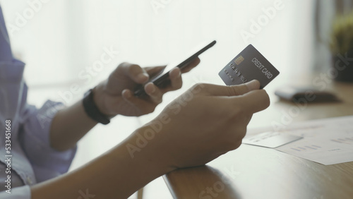 close up of a person working on a laptop with credit card.