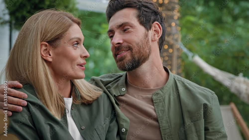 Loving married couple husband and wife Caucasian bearded man and blonde woman 40s spouses sit outdoors looking into distance dreaming contemplating thinking about future talking conversation cuddling
