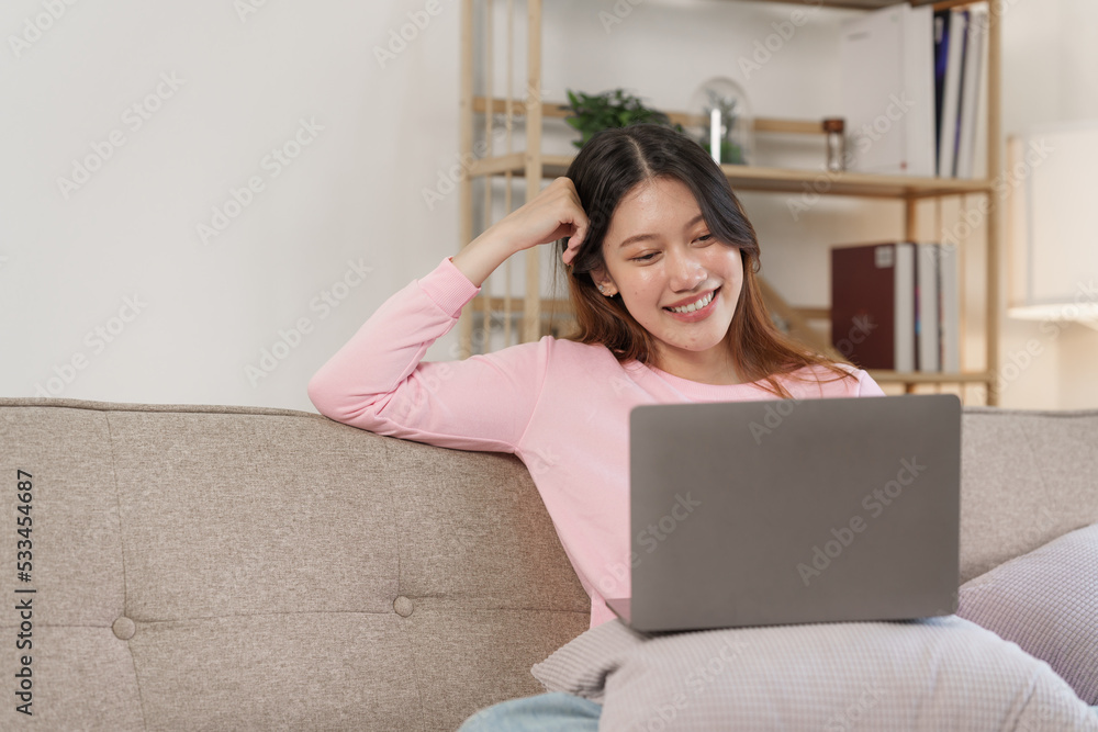 Happy young attractive smiling asian woman enjoying relax time at apartment.