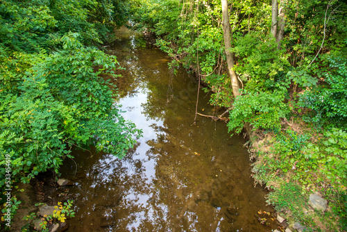 a gorgeous autumn landscape in the park with the rippling waters of Irwin Creek surrounded by lush green trees at Frazier Park in Charlotte North Carolina USA photo