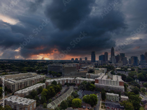 an aerial shot of the skyscrapers and office buildings in the city skyline with lush green trees and with powerful clouds at sunset at Frazier Park in Charlotte North Carolina USA photo