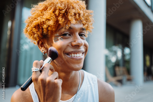 African american visagist holding brush and preparing makeup