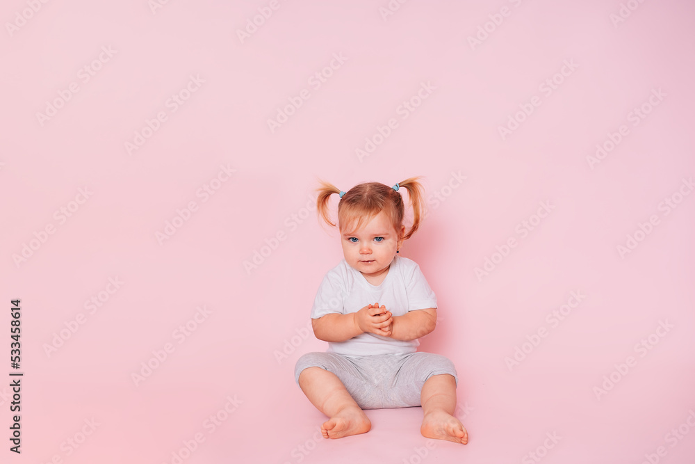 a two-year-old beautiful girl looks skeptical, isolated on a pink background. A look full of doubt. Distrust. Cheating a child. A bad joke. a two-year-old beautiful girl looks skeptical, isolated on a pink background. A look full of doubt. Distrust. Cheating a child. A bad joke.