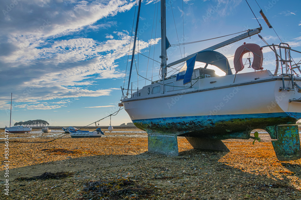 Stranded boats at sunset near Les Pierres Plates due low tide, Brittany, France Stranded boats at sunset near Les Pierres Plates due low tide, Brittany, France