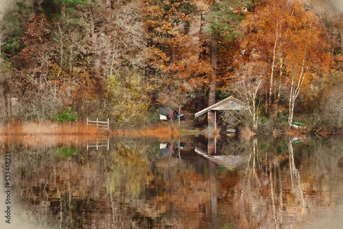 Stunning landscape image of boathouse on Derwentwater during vibrant Autumn sunrise with woodland surrounding the lake