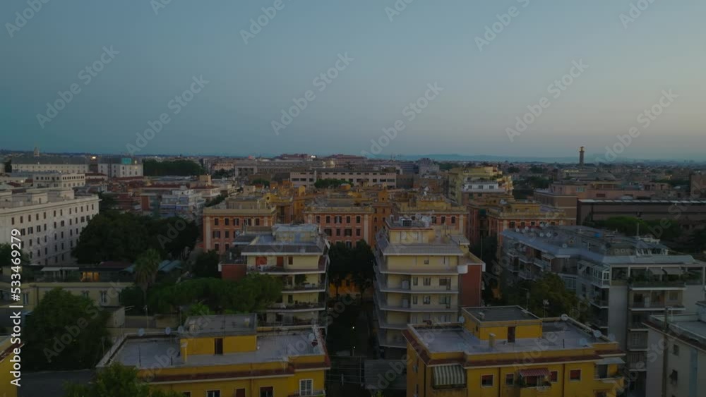 Forwards fly above buildings in urban borough. Apartment buildings in housing estate in large city at twilight. Rome, Italy Forwards fly above buildings in urban borough. Apartment buildings in housing estate in large city at twilight. Rome, Italy