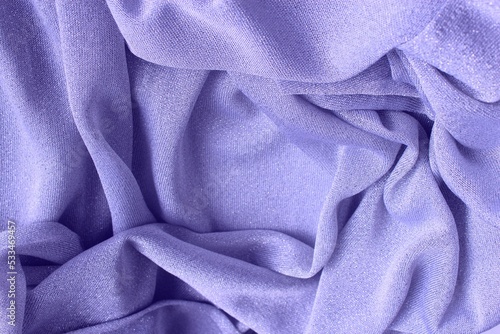 Light purple shiny fabric, folded in folds. Shiny knitwear, organza. Solid background.