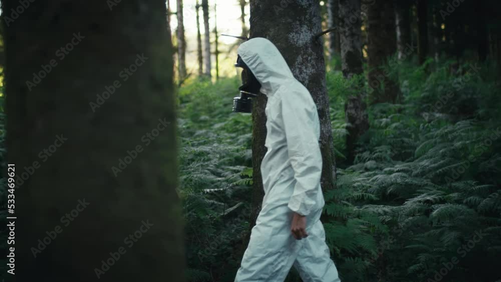 Man with contamination white suit and gas mask walks in the mountains Man with contamination white suit and gas mask walks in the mountains