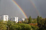 Double rainbow over white houses and trees