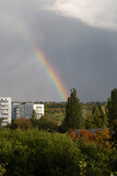 Rainbow over white houses and trees