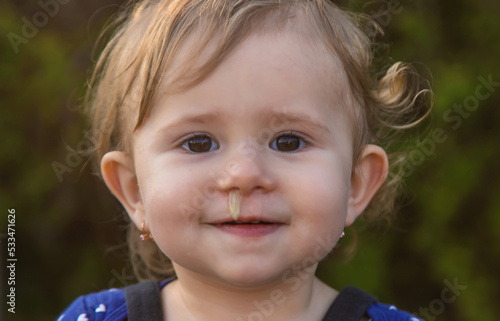 Baby plays snot in the street with a cold nose. Selective focus.