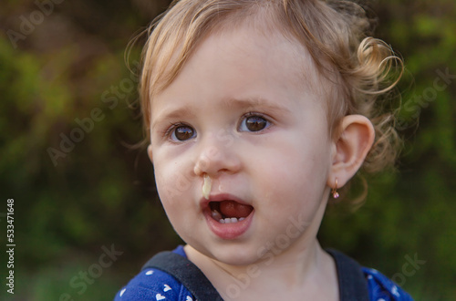 Canvas Print Baby plays snot in the street with a cold nose. Selective focus.