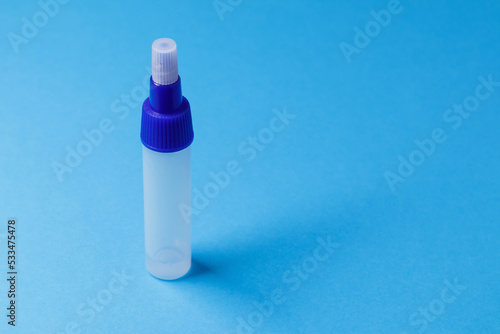 Test tube, container on blue background with free space for text, copy space. Virus detection, transfer analysis, drug testing, concept of health examinations photo