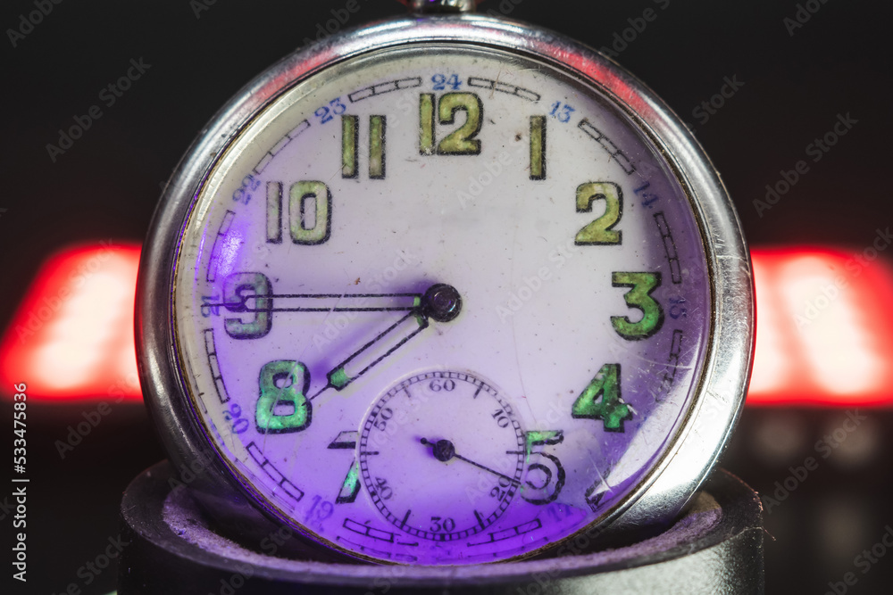 An old pocket watch with dangerous radioactive fluorescent paint. Scratches on the glass. Silver