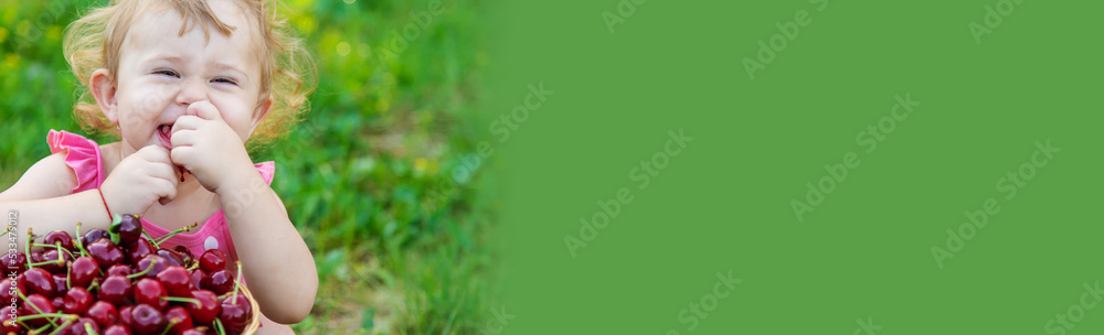 The child eats cherries in the garden. Selective focus. The child eats cherries in the garden. Selective focus.
