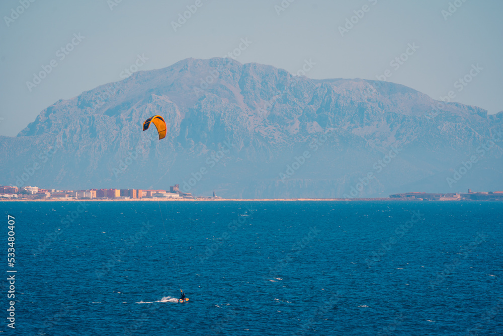 Kite surfer sailing on blue ocean water Kite surfer sailing on blue ocean water