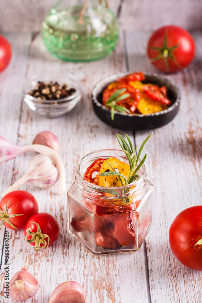 Homemade sun-dried tomatoes with spices, garlic and herbs in a jar and fresh vegetables. Vertical Homemade sun-dried tomatoes with spices, garlic and herbs in a jar and fresh vegetables. Vertical
