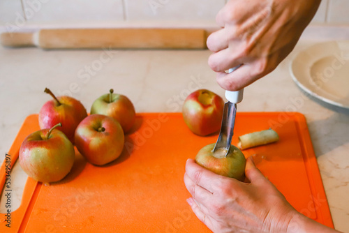 Woman removing the core and pips from the juicy apple with metal apple corer