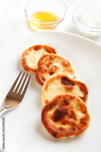 Photographic Recipe of Ukrainian Cottage Cheese Pancakes, Also Known as Syrnyky. Step 5: Finished Dish. Served With Honey And Sour Cream.