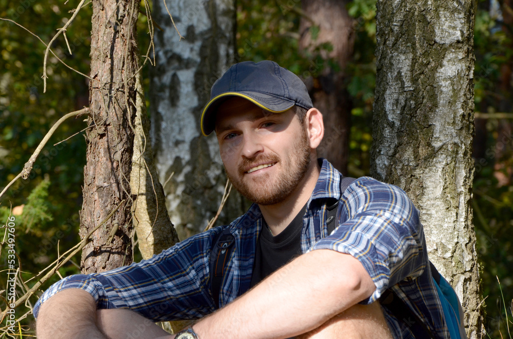 young man with a beard in a cap portrait on the background of nature young man with a beard in a cap portrait on the background of nature