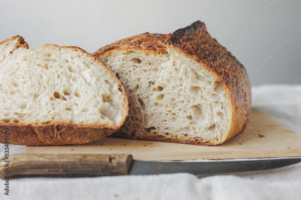 Round fresh bread lies on the cutting board. Baking and confectionery in a bakery or restaurant. homemade yeast-free sourdough bread. Healthy food