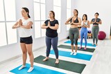 Group of young hispanic women concentrated training yoga at sport center.