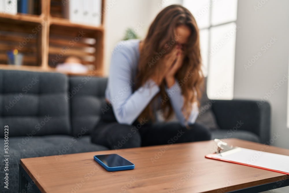 Young beautiful hispanic woman stressed sitting on sofa at home