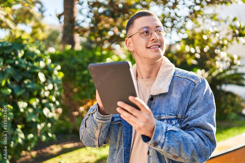 Young hispanic man smiling confident using touchpad at park Young hispanic man smiling confident using touchpad at park