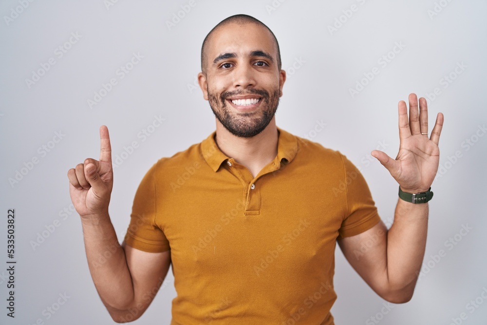 Hispanic man with beard standing over white background showing and pointing up with fingers number six while smiling confident and happy. Hispanic man with beard standing over white background showing and pointing up with fingers number six while smiling confident and happy.