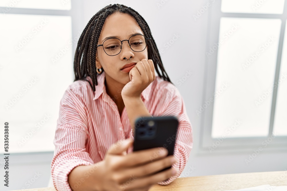 Young african american woman using smartphone working at office Young african american woman using smartphone working at office