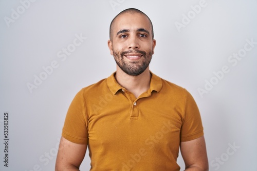 Hispanic man with beard standing over white background with hands together and crossed fingers smiling relaxed and cheerful. success and optimistic © Krakenimages.com