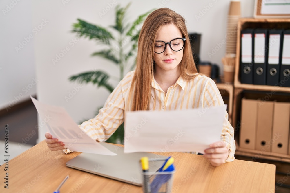 Young blonde woman business worker reading document at office Young blonde woman business worker reading document at office