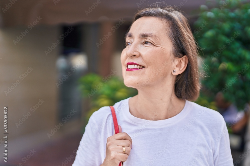 Middle age woman smiling confident looking to the side at street Middle age woman smiling confident looking to the side at street