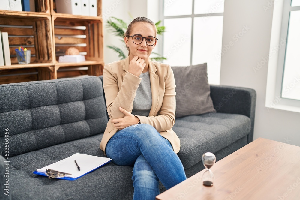 Young woman working at consultation office looking confident at the camera smiling with crossed arms and hand raised on chin. thinking positive. Young woman working at consultation office looking confident at the camera smiling with crossed arms and hand raised on chin. thinking positive.