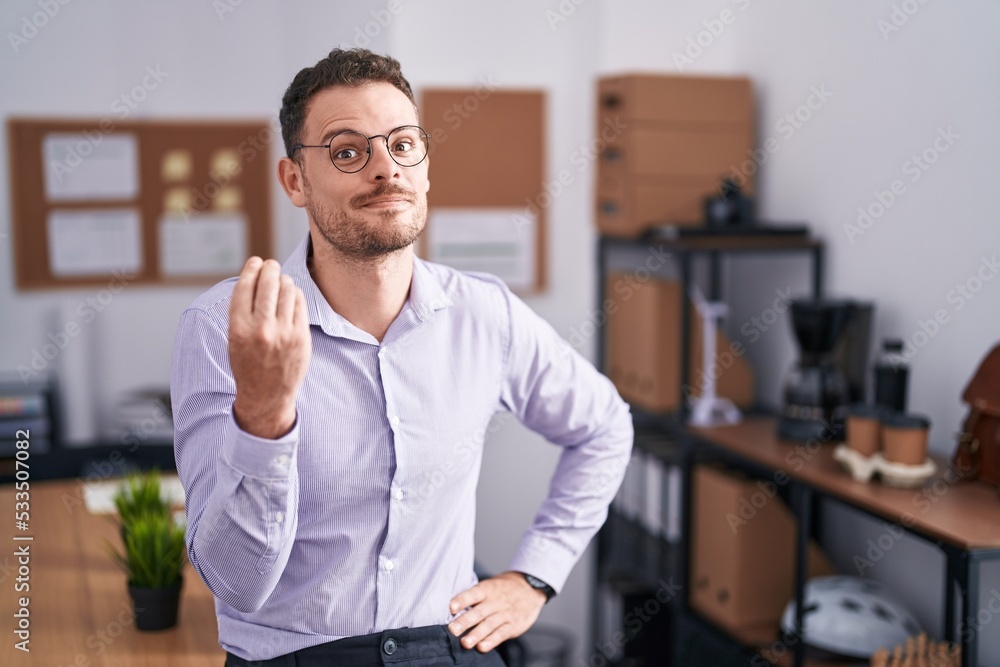 Young hispanic man at the office doing italian gesture with hand and fingers confident expression Young hispanic man at the office doing italian gesture with hand and fingers confident expression